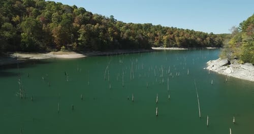 A View Of Old Wood Pilings Over Lake In Eagle Hollow Cave, Arkansas, United States. Aerial Pullback