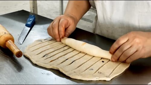 Bäckereipersonal bereitet ein Brötchen zu