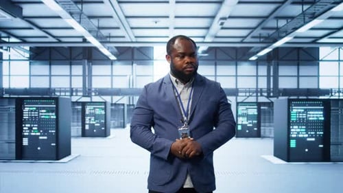 Technician Walking Between Server Rows in Data Center Doing Inspection