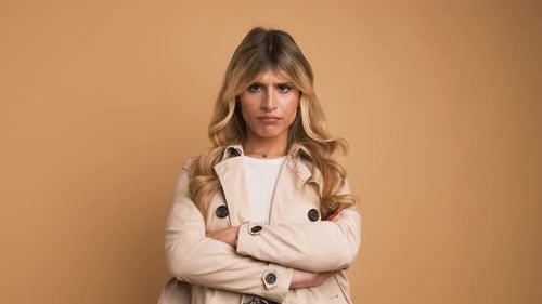 Femme transgenre déçue hochant la tête sur fond beige
