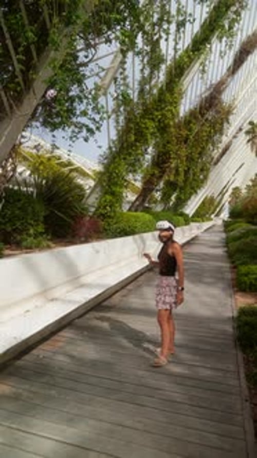 Young Woman Engaging with Virtual Reality Technology in Contemporary City Green Area