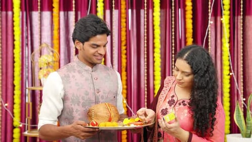 Couple Lighting Lamps for Diwali Celebration Indoors