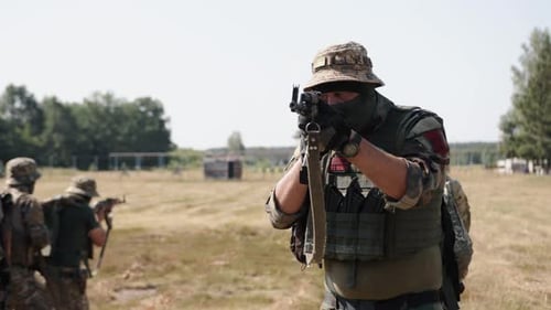 Soldiers Armed with Rifles Training Outdoors