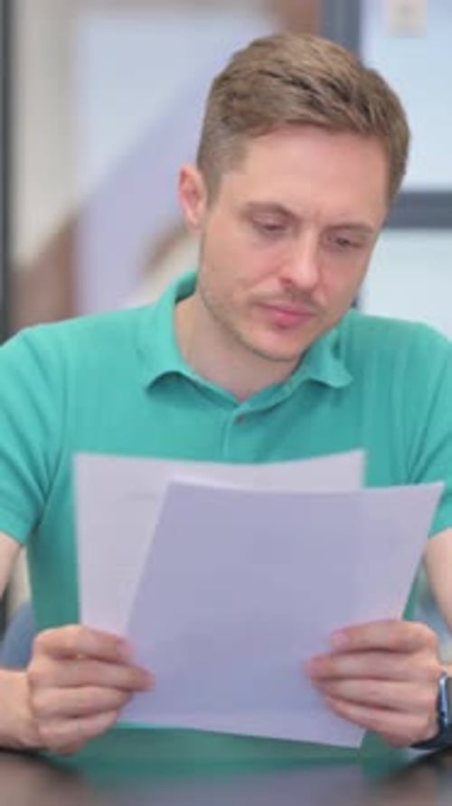 Vertical Video of Mature Adult Man Reading Documents in Office