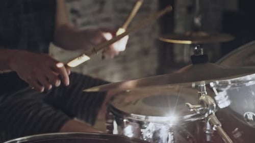Crop View of Man Playing Drums in Bright Illumination on Modern Stage During Performance