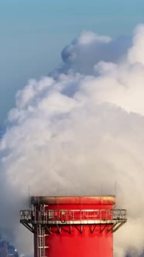 Industrial Smokestack Emitting Vapor into a Bright Sky
