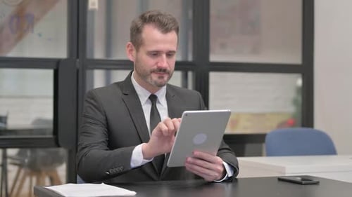 Professional Man Using Tablet Celebrates Good News