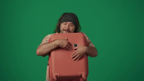 Man Hugging a Suitcase Against a Green Screen