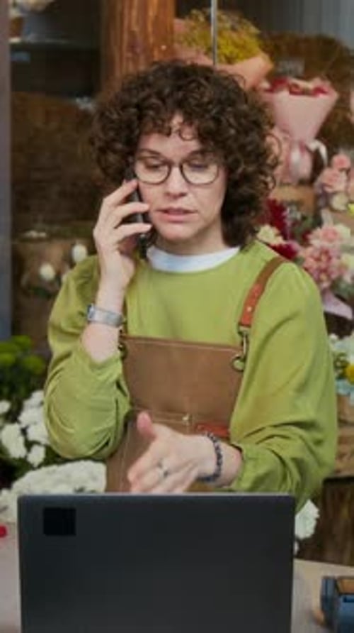 Woman Talks on Phone at Flower Shop Computer