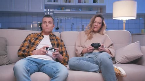 Couple Plays Video Games on Living Room Couch