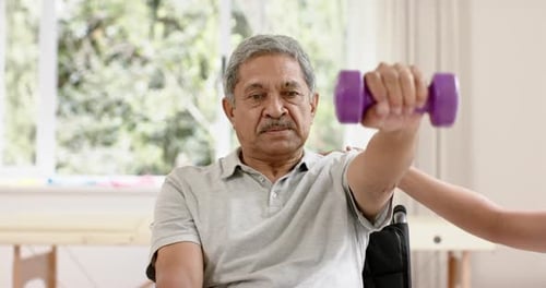Senior Man Lifting Dumbbell in Physical Therapy