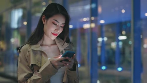 Asian Girl Standing Outside with Cellphone Typing Message Receive SMS From Bank Feels Excited