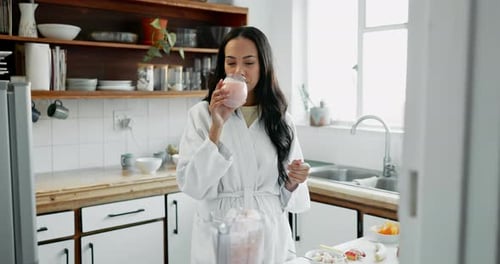 Woman in Robe Drinks Pink Smoothie in Kitchen