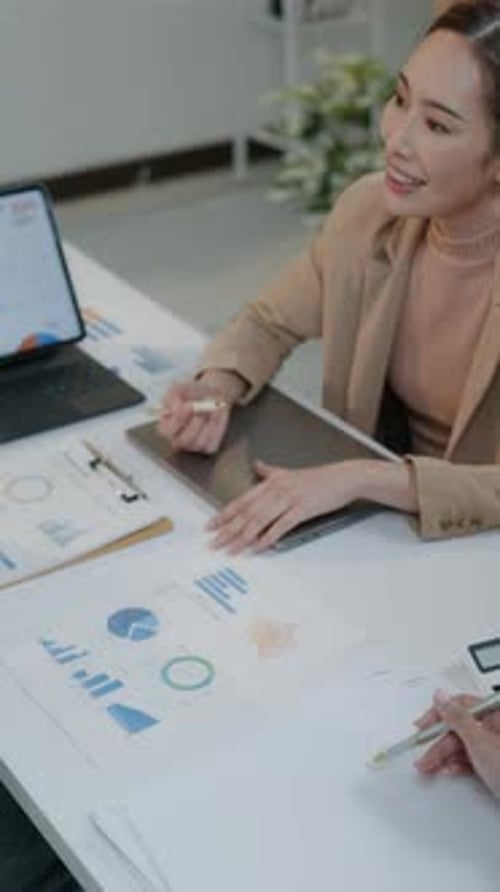 Women Discussing Charts in Office Environment