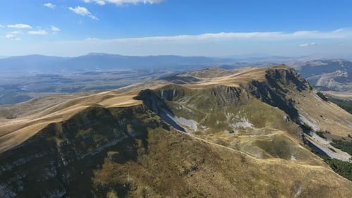 Flight over beautiful mountain peaks covered with grass. Mountain from above on a sunny autumn day.
