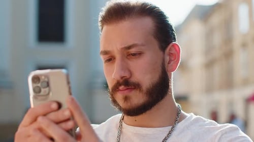 Man Checks Smartphone in City Close Up