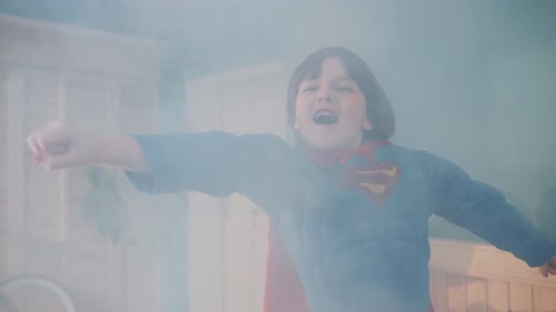 Boy Wearing Super Hero Costume Pretends to Fly