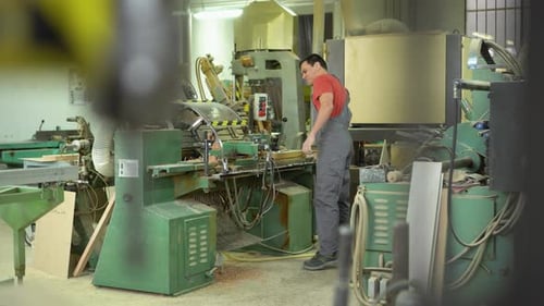 Concentrated Carpenter Working on Equipment in Workshop