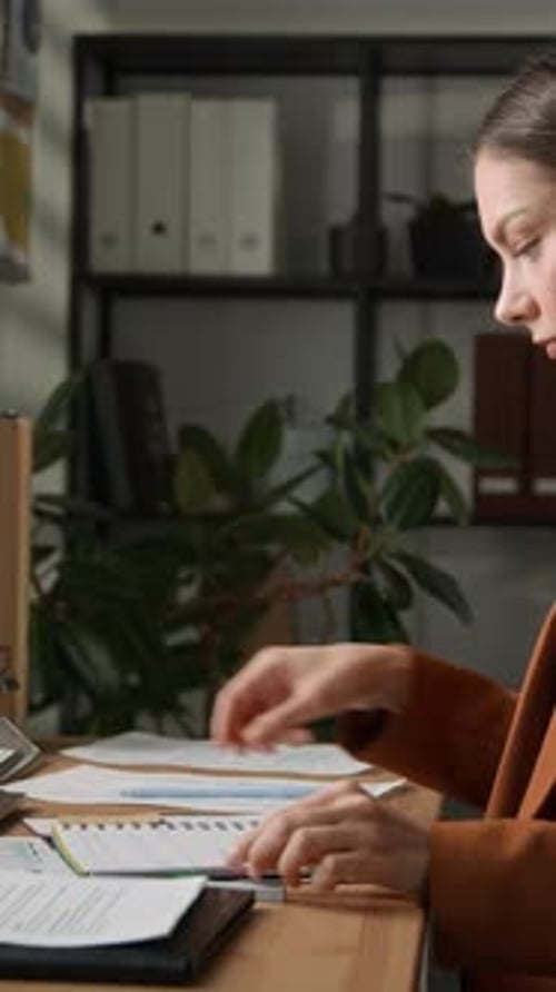 Female Office Worker Using Black Notebook at Workplace Desk