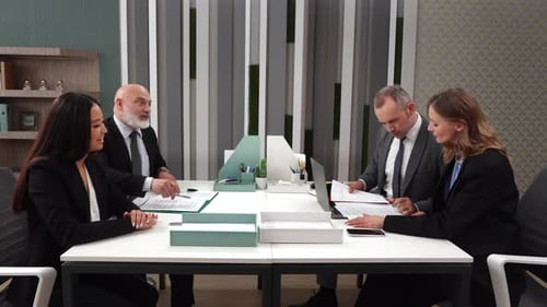 Office Meeting with Four Professionals Discussing Strategy