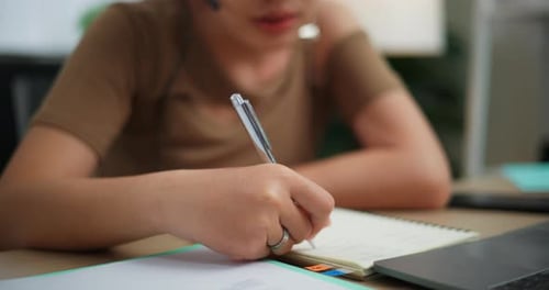 Woman writing in notebook in office environment