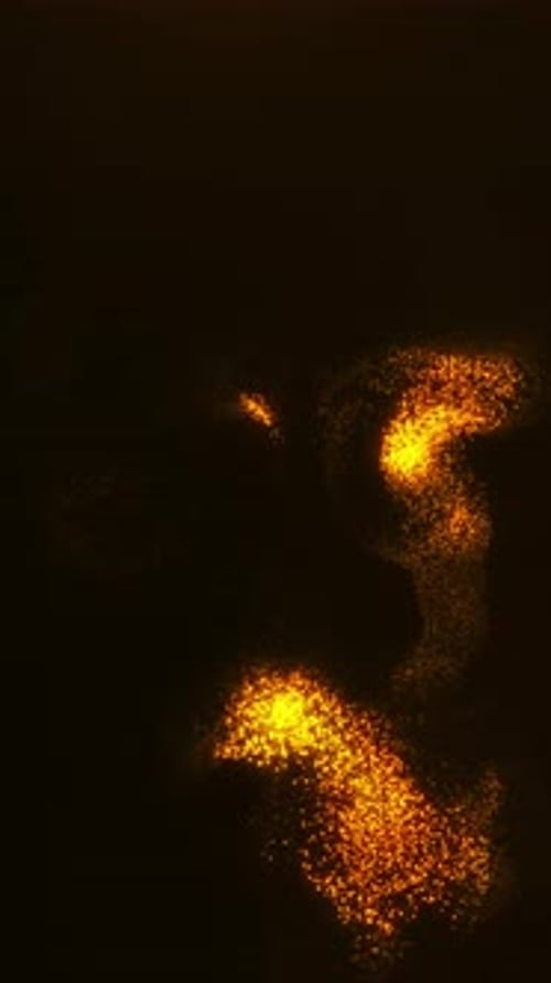 Vertical golden particle streams forming fluid glowing patterns with warm shimmering dust