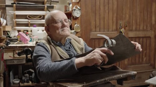 Senior Elderly Master Jeweler in Wheelchair Works in a Workshop