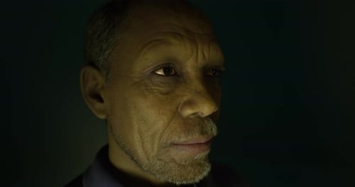 Portrait d'un homme âgé dans une lumière tamisée avec une expression réfléchie