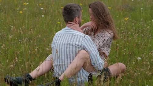 Happy Couple Enjoying Each Other in the Middle of Field Outdoors Woman Sitting on the Man and