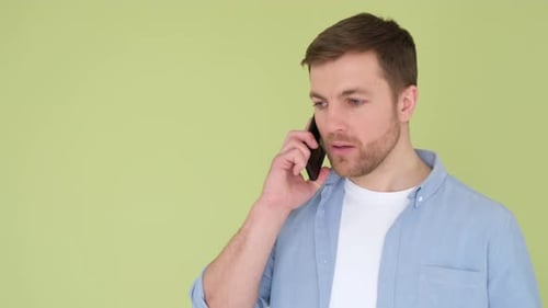 Aggressive Man Talking on Smartphone and Shouting Displeased Isolated on Background in Studio