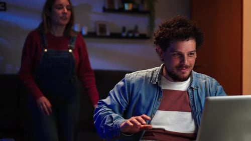 Young Adults Laughing While Using Computer at Home