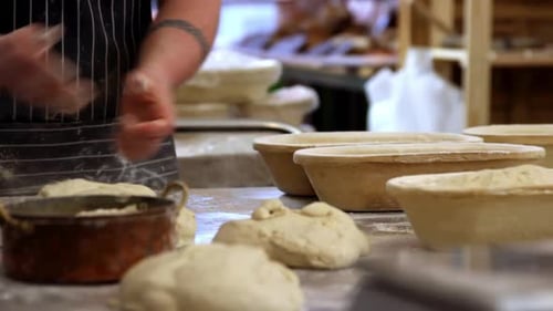baker handling and kneading dough, close