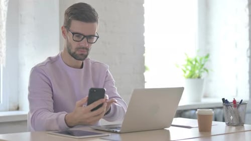 Young Adult Working With Technology in Bright Office