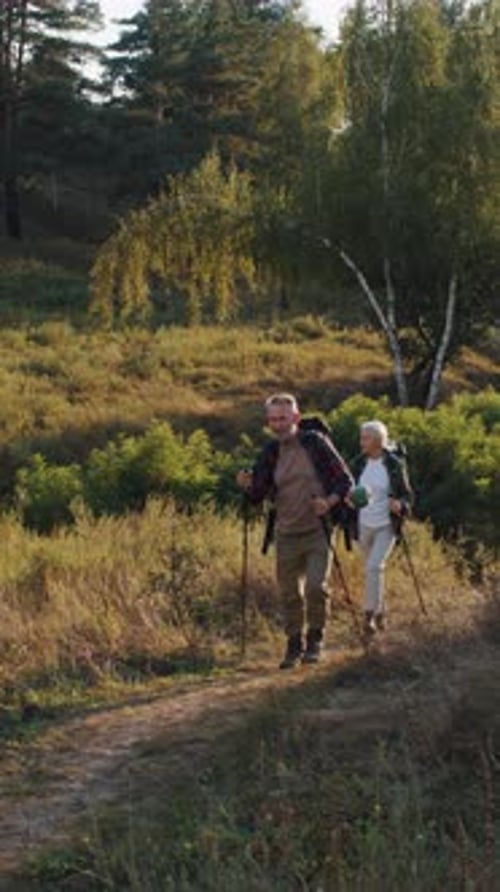 Active Retired Friends with Canes Walk Across Autumn Countryside