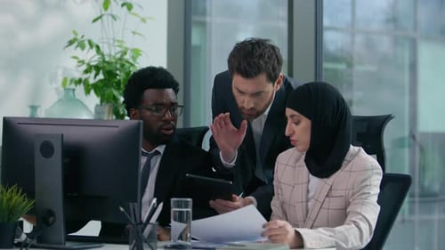 Equipe de negócios diversificada discutindo no escritório, discussão furiosa, documentos, conflito de trabalho em computador, muçulmano