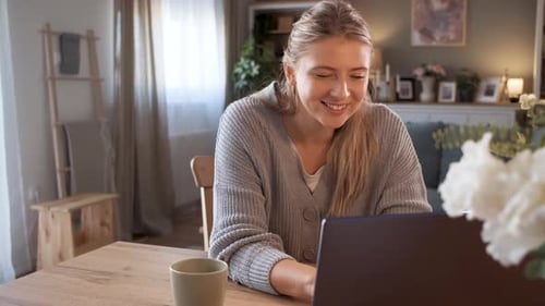 Woman Working on Laptop at Home Smiling