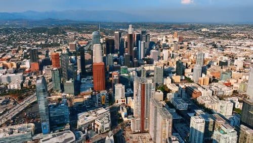 Morning in the downtown of LA, California, USA. Green hills and mountain range at backdrop.