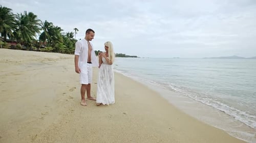 Loving Couple Walking Arm in Arm Along a Beach