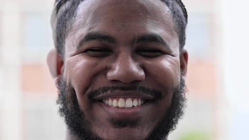 Smiling Young Man Close-Up Portrait in Front of Building