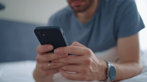 Man Using Mobile Phone in Bed