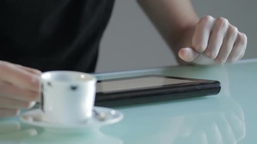 Person Using Tablet Computer With Coffee Cup