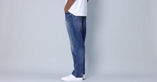 Man Displaying Denim Jeans in Studio Setting
