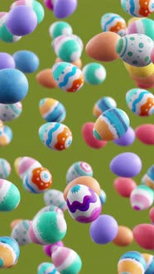 Looping video of decorated Easter eggs falling in slow motion on green background