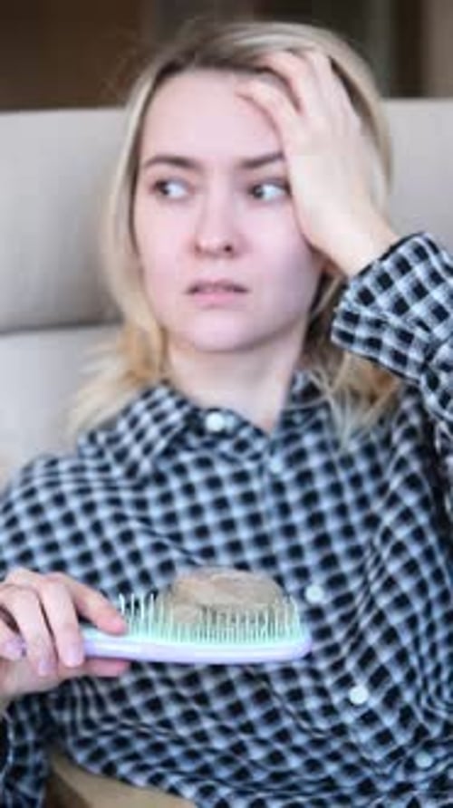 Young Woman with Hair Loss Problem She is Looking at the Brush and Hairball