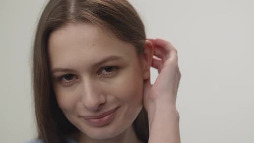 Woman Smiling and Touching Her Face