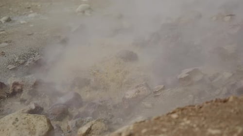 Steaming methane and mineral pool bubbles and froths against light rocks and mud. Shot in glorious s