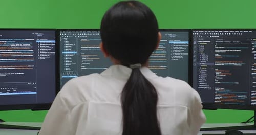Back View Asian Woman Developer Boring While Write Code With Multiple Screens In Green Screen Studio
