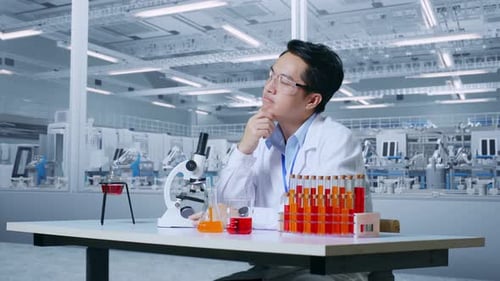 Excited Scientist Working Under Microscope in Lab