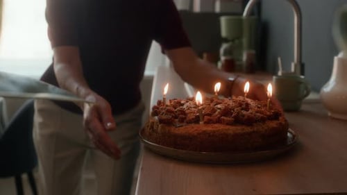 Woman Taking Away Chocolate Cake with Burning Candles for Birthday Surprise