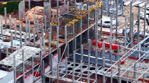 Workers are Constructing a Large Multi-story Building With Steel Frameworks and Concrete Structures